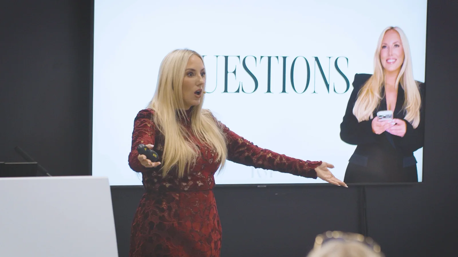 A speaker presenting to an audience at a beauty industry event